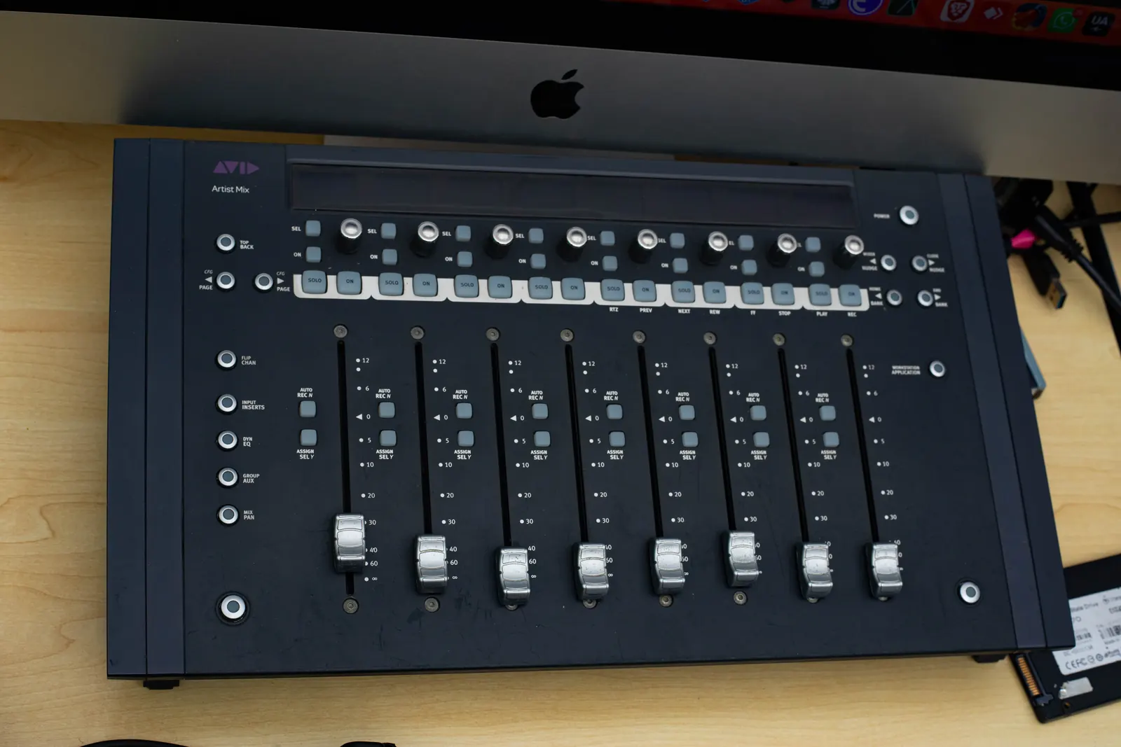 Close view of faders on a control surface in the studio.