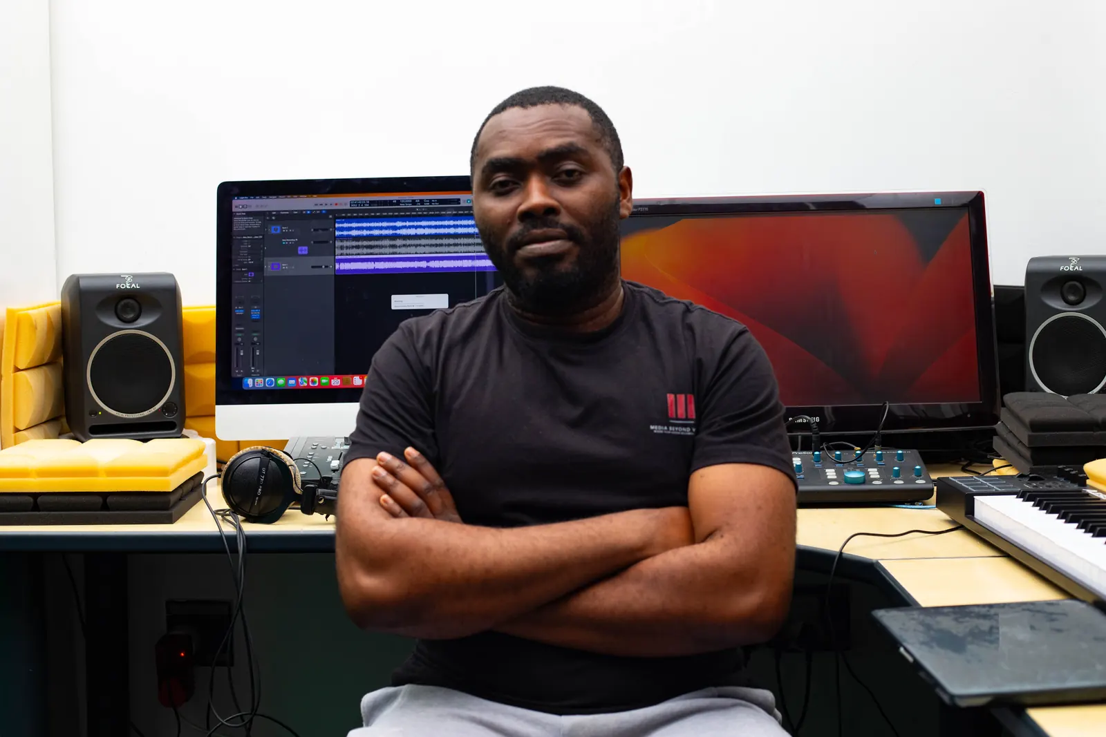 Studio engineer seated at the SN7 desk, facing the camera between two monitors.